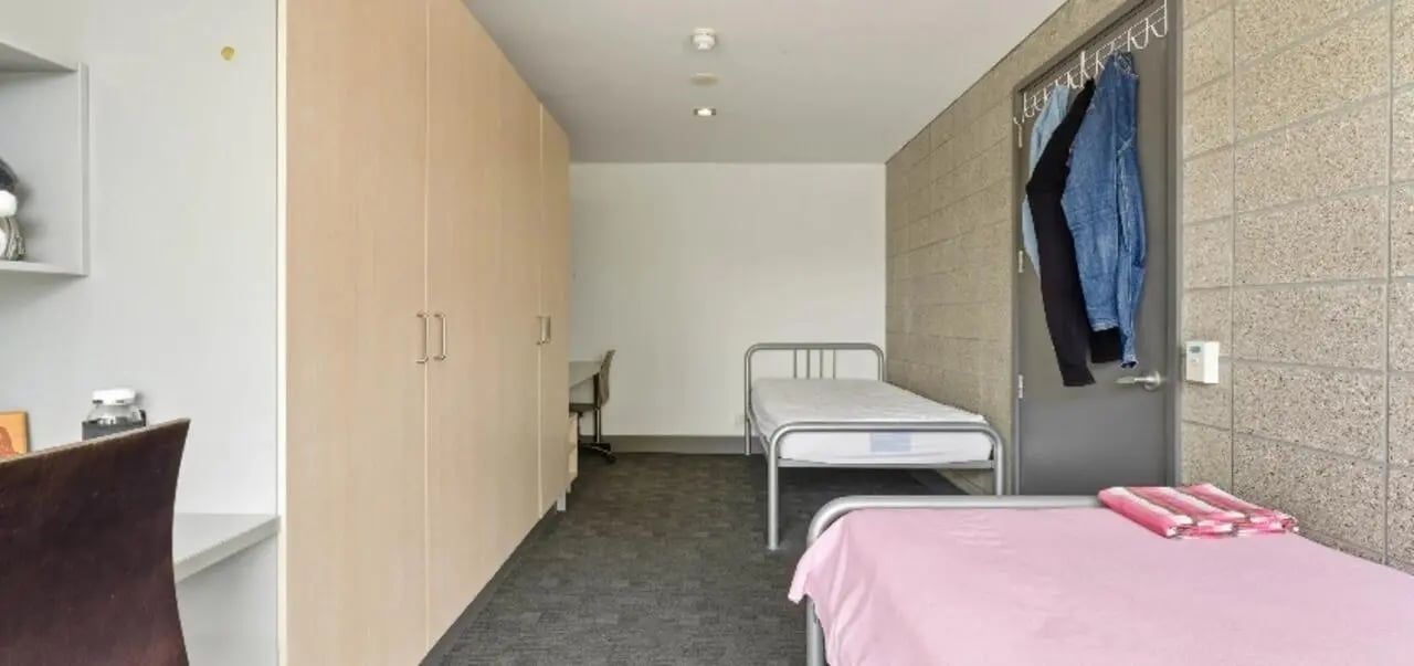 Two beds wardrobe and desk student bedroom at Student Living Auckland in Auckland Student Accommodation