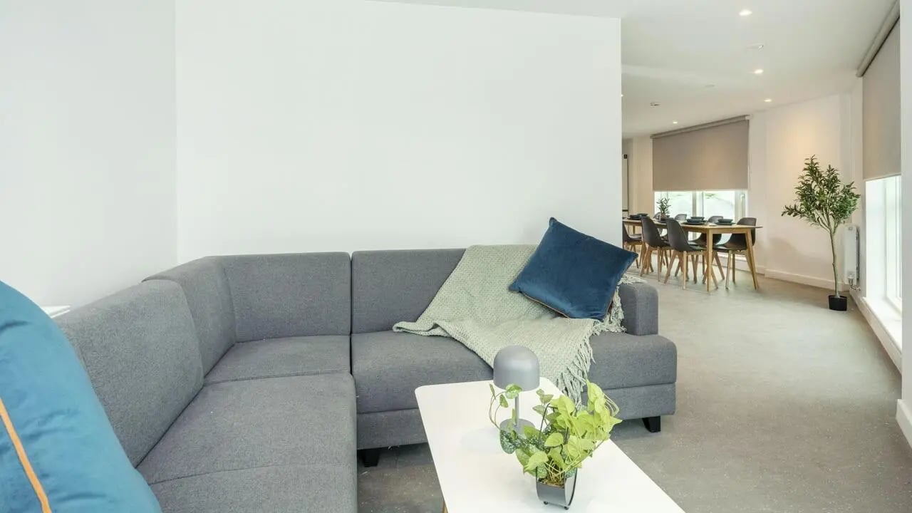 Grey sectional sofa white table dining area living room at Timber Yard in Bristol Student Accommodation