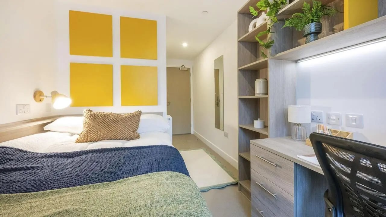Bed desk shelving mirror yellow wall decor bedroom at Timber Yard in Bristol Student Accommodation