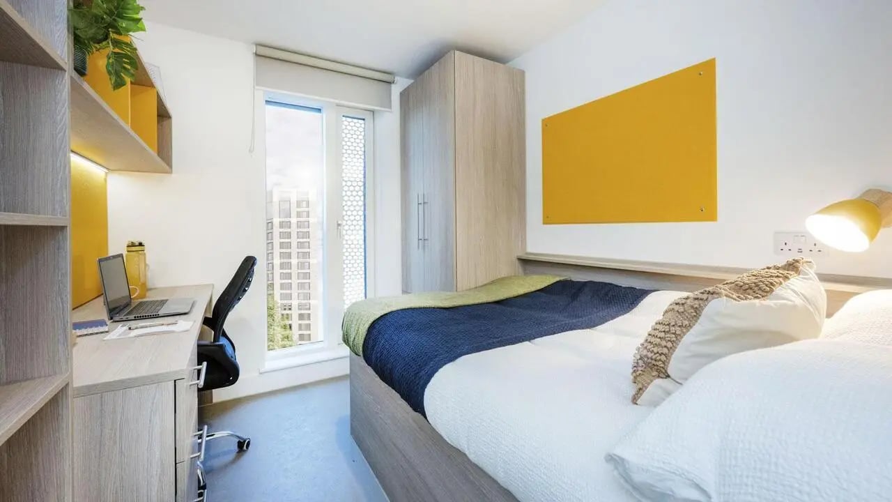 Desk bed wardrobe and yellow board bedroom at Timber Yard in Bristol Student Accommodation
