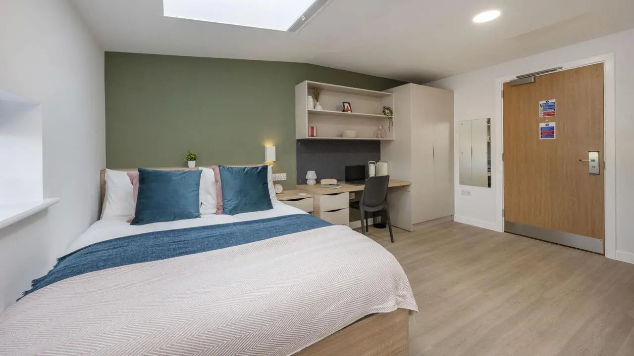 Bed desk chair shelf wardrobe and door bedroom at Waterloo House in York Student Accommodation