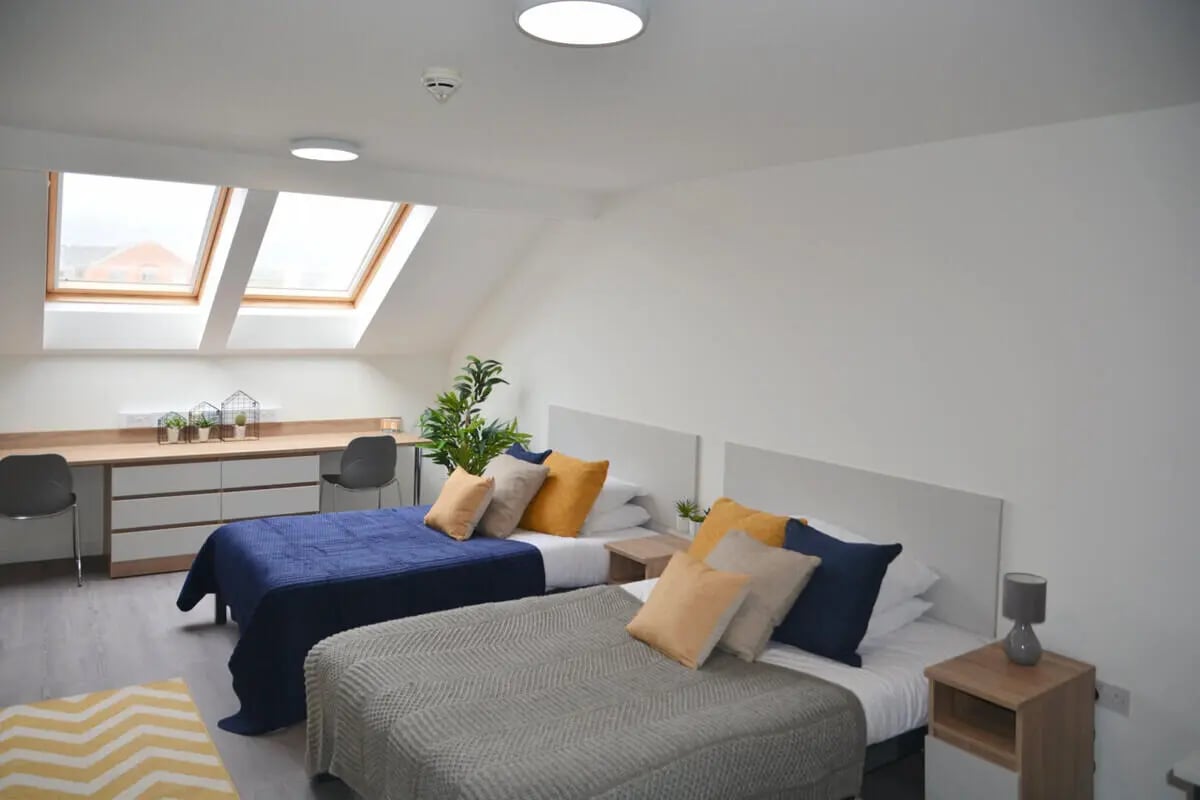 Two beds desks skylights and chairs bedroom at Abode York in York Student Accommodation