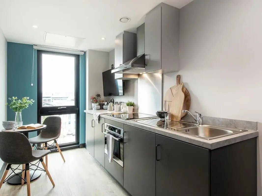 Modern kitchen with small dining table kitchen area at Zenith in Cardiff Student Accommodation