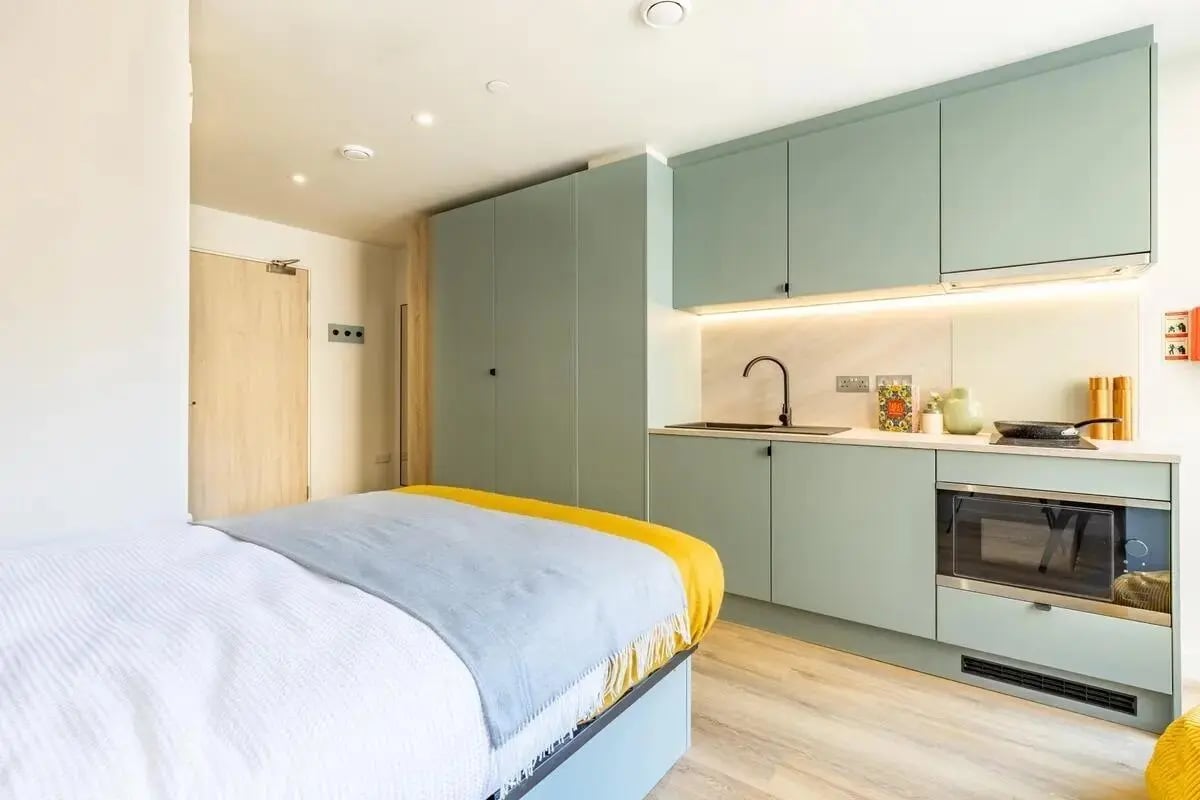 Bed with kitchen area and cabinets kitchen at Centre Court in Nottingham Student Accommodation