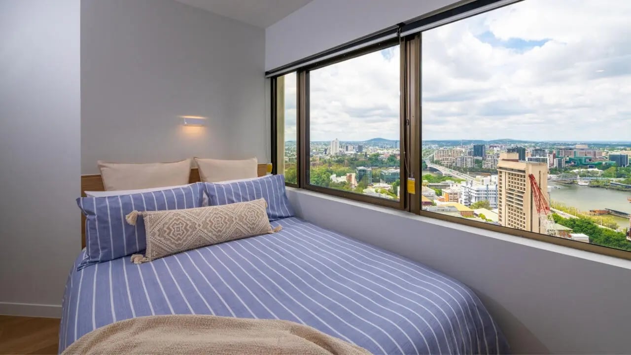 Striped bed with city view bedroom at UniLodge Brisbane City in Charleston Student Accommodation