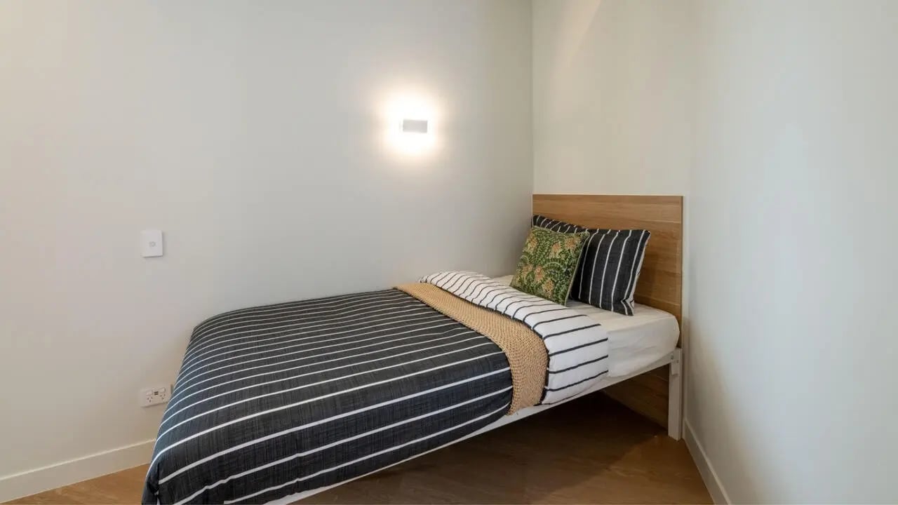 Striped bedding and pillows on bed Bedroom at UniLodge Brisbane City in Charleston Student Accommodation