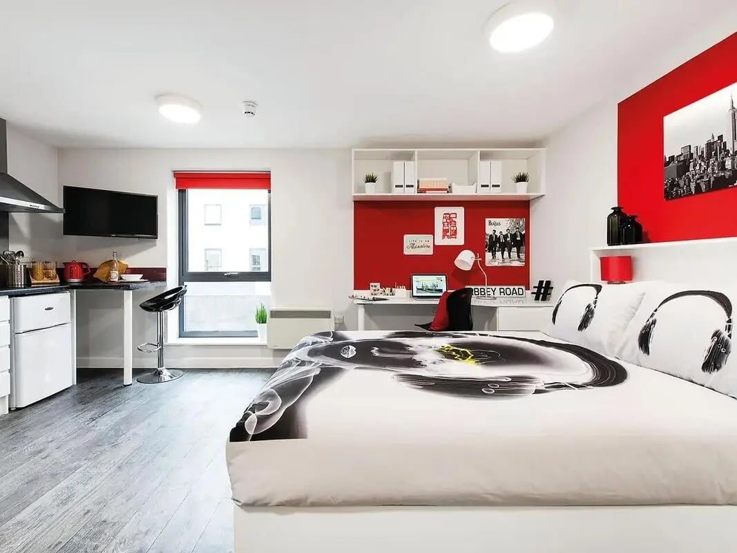 Bed desk kitchen area and television bedroom at Yugo Arofan House in Cardiff Student Accommodation