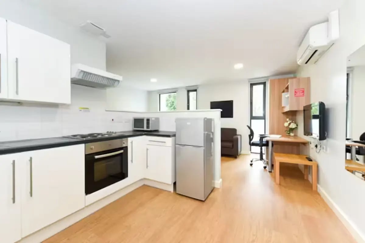 Kitchen with oven microwave fridge and living area living room at The Summit Leicester in Leicester Student Accommodation