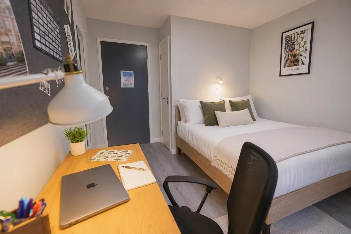 Desk bed with laptop and pillows bedroom at Madison Gardens in Nottingham Student Accommodation