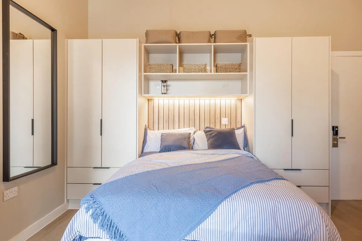 Bed with blue throw shelving and closets bedroom at Fitz and Knox in Cardiff Student Accommodation