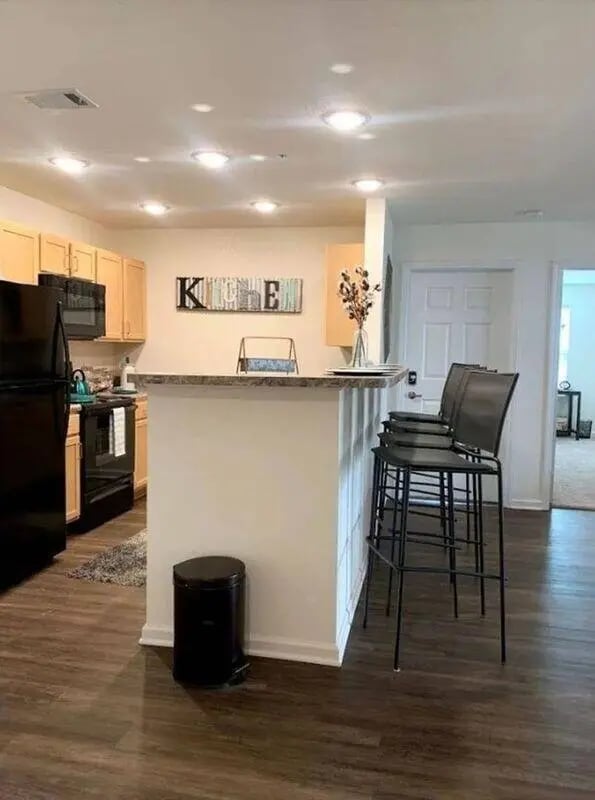 Black refrigerator cabinets counter bar stools kitchen at Waypoint at Hammond in Hammond Student Accommodation