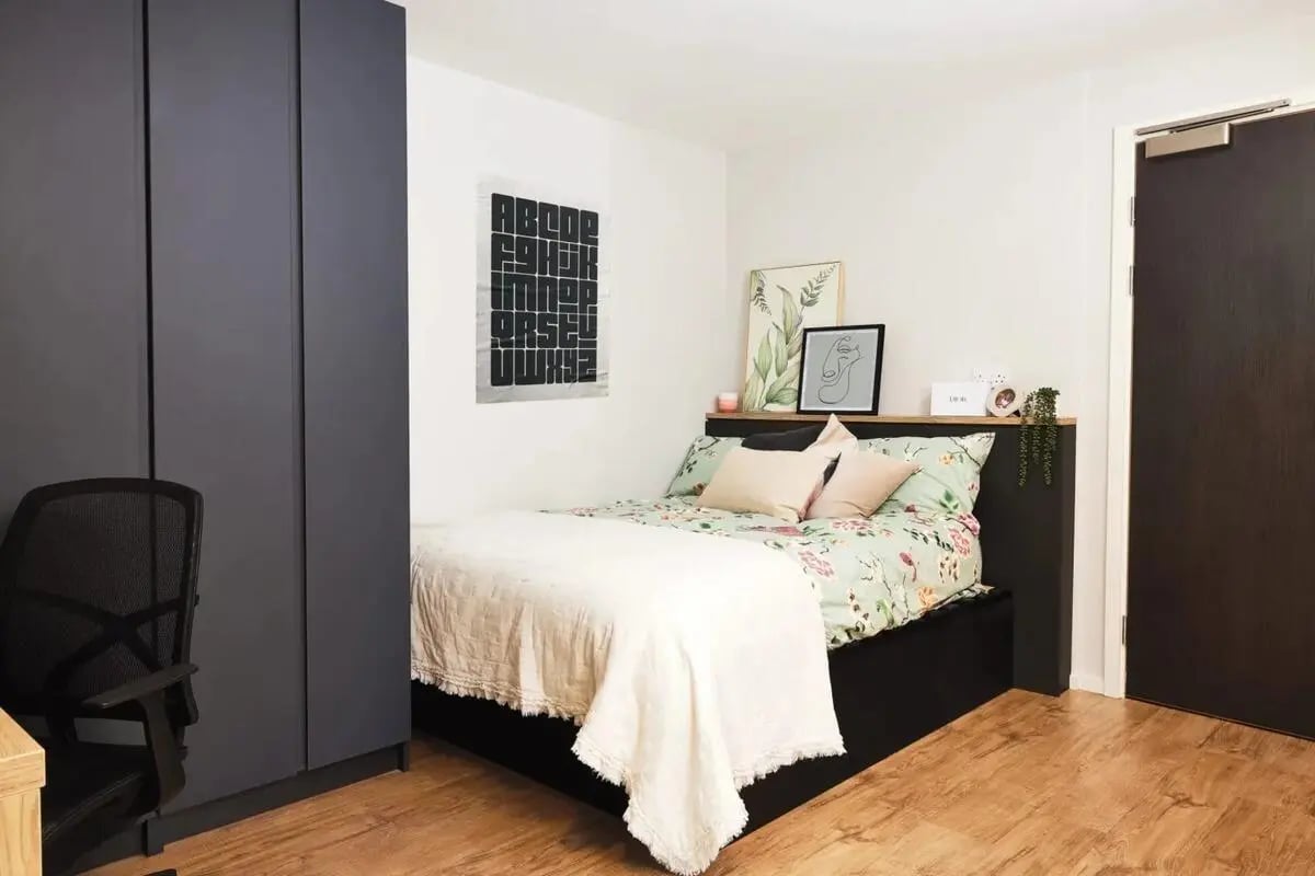 Bed with floral bedding and chair bedroom at Vita Student Portland Crescent in Leeds Student Accommodation
