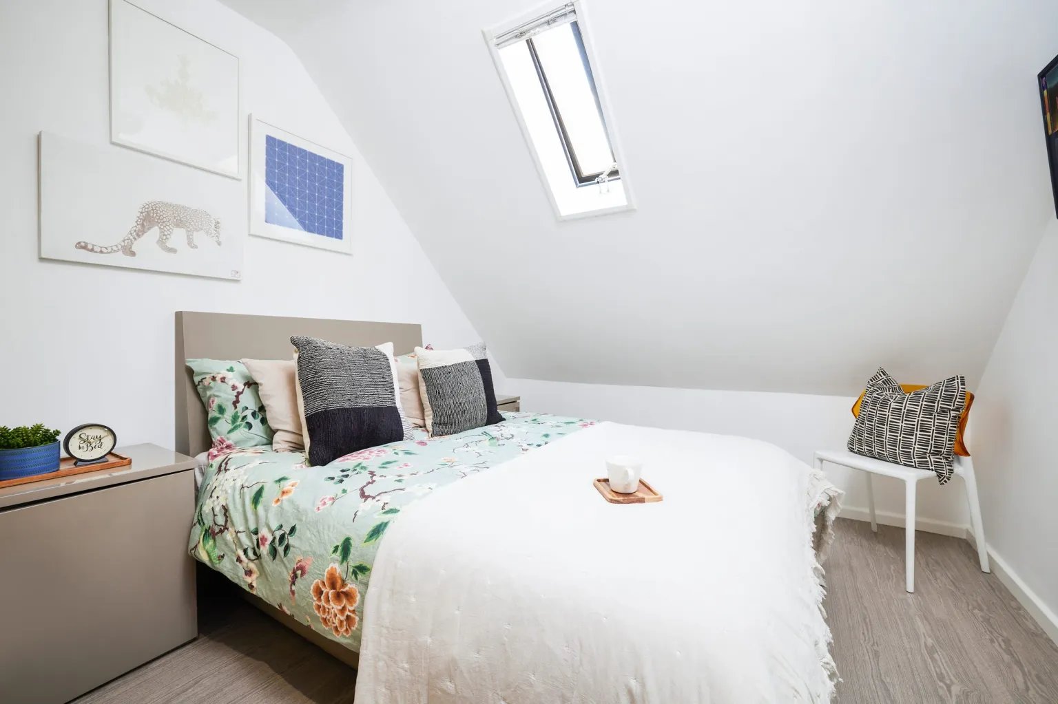 Bed with floral duvet pillows skylight and chair Bedroom at Vita Student Crosshall Street in Liverpool Student Accommodation