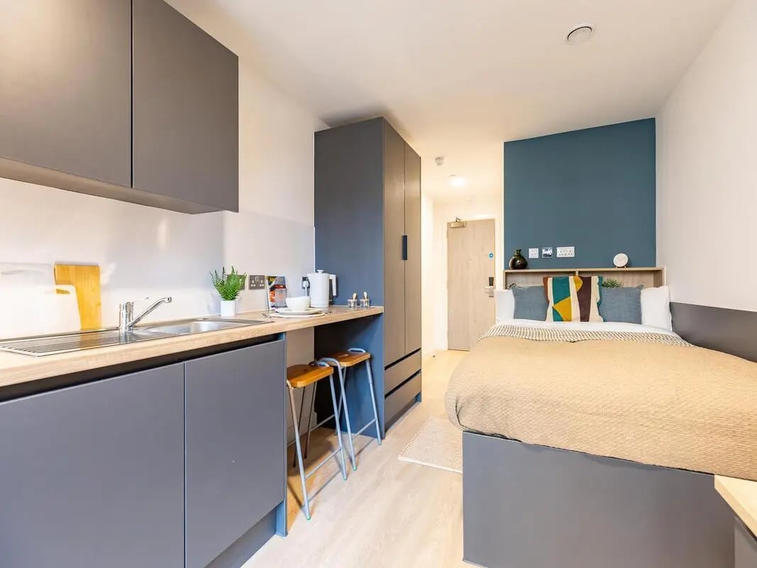 Kitchenette counter sink and bed with pillows Bedroom at Fabric in Nottingham Student Accommodation