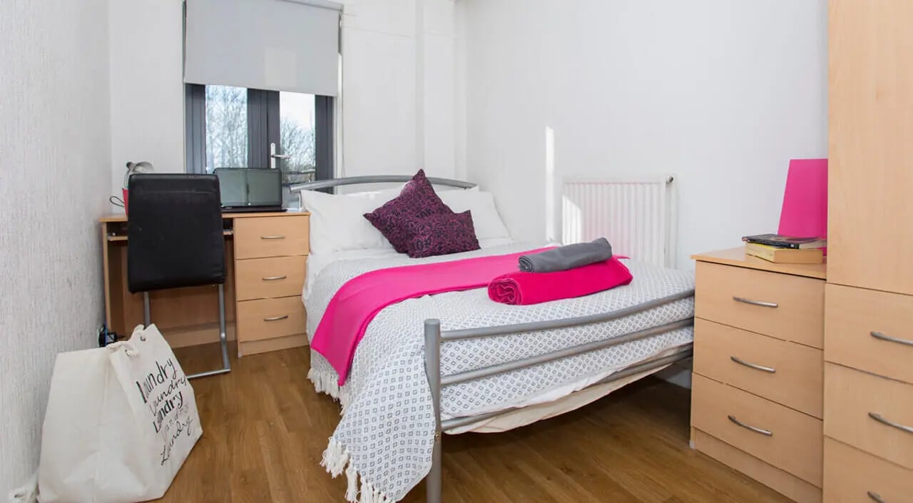 Bed desk chair and laundry bag bedroom at Surrey Quays Landale House in London Student Accommodation