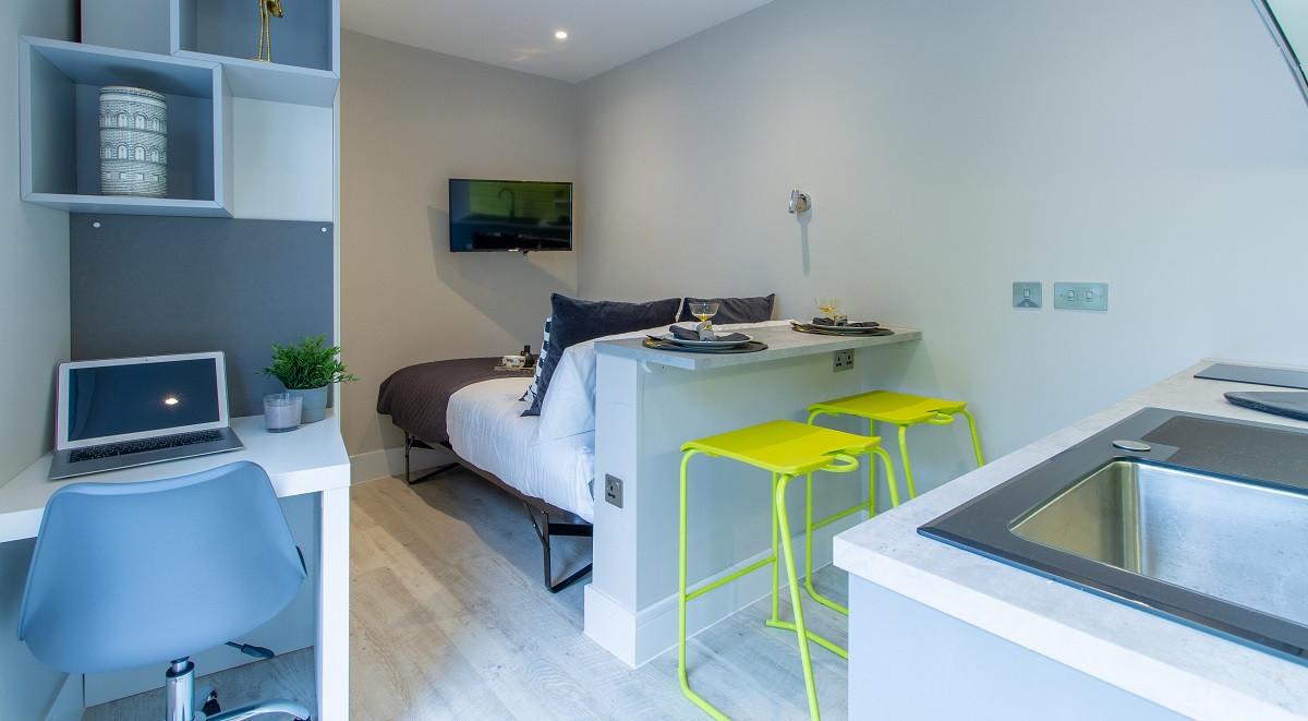 Bed desk kitchen counter with stools studio apartment at AXO Seven Sisters in London Student Accommodation