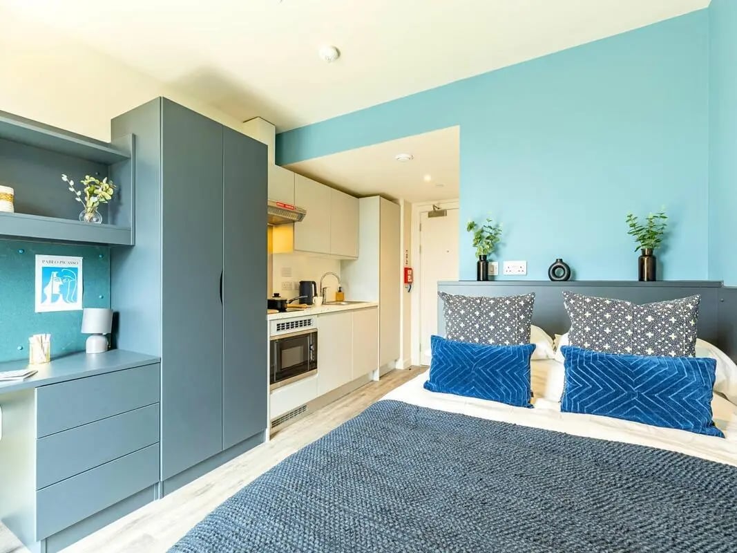 Bed with blue pillows and wardrobe kitchen bedroom at Pershore Junction in Birmingham Student Accommodation