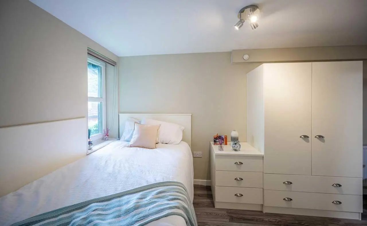 Bed pillows throw blanket dresser wardrobe bedroom at Peterson Hall in Dundee Student Accommodation