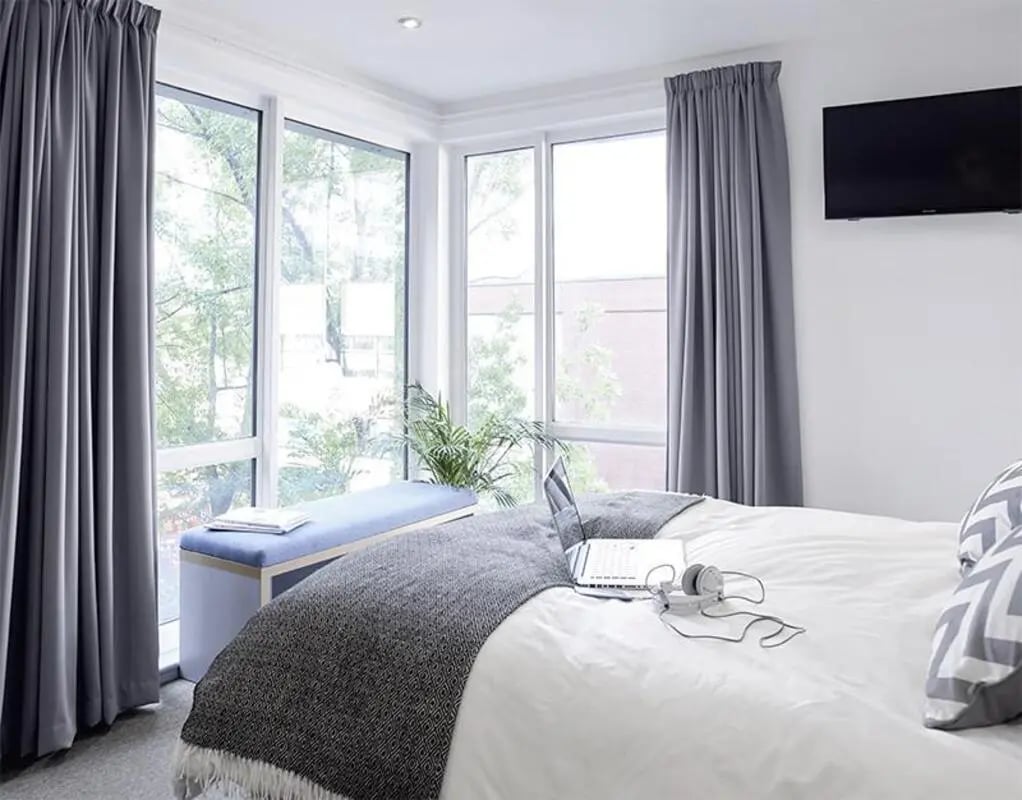 Bed with laptop bench and large window bedroom at Lace Market Studios in Nottingham Student Accommodation