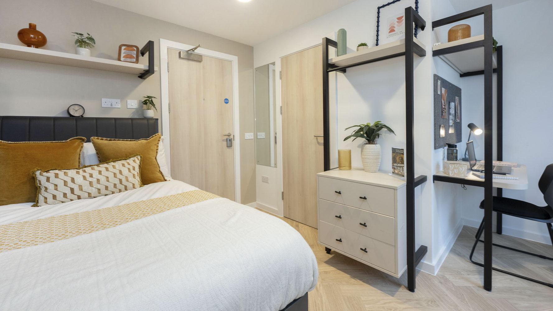 Bed pillows dresser desk shelves and chair bedroom at Arcadian in Nottingham Student Accommodation