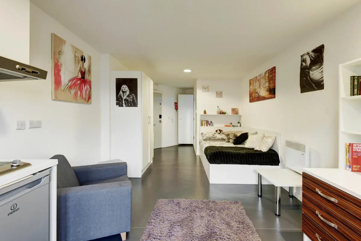 Bed with black blanket and desk student room at Lucas Studios in Birmingham Student Accommodation