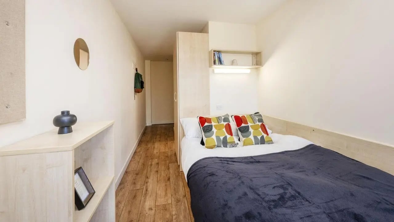 Bed with decorative pillows and shelf bedroom at Rockingham House in Sheffield Student Accommodation