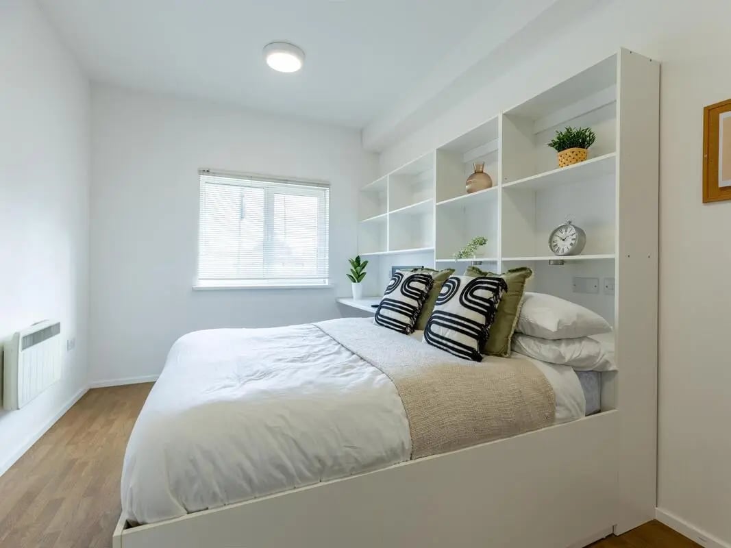 Bed with shelves above and a window Bedroom at St Augustine's House in Plymouth Student Accommodation