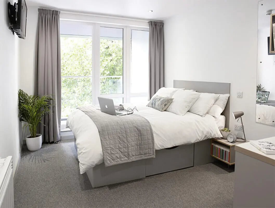 Bed laptop plant and window bedroom at Lace Market Studios in Nottingham Student Accommodation