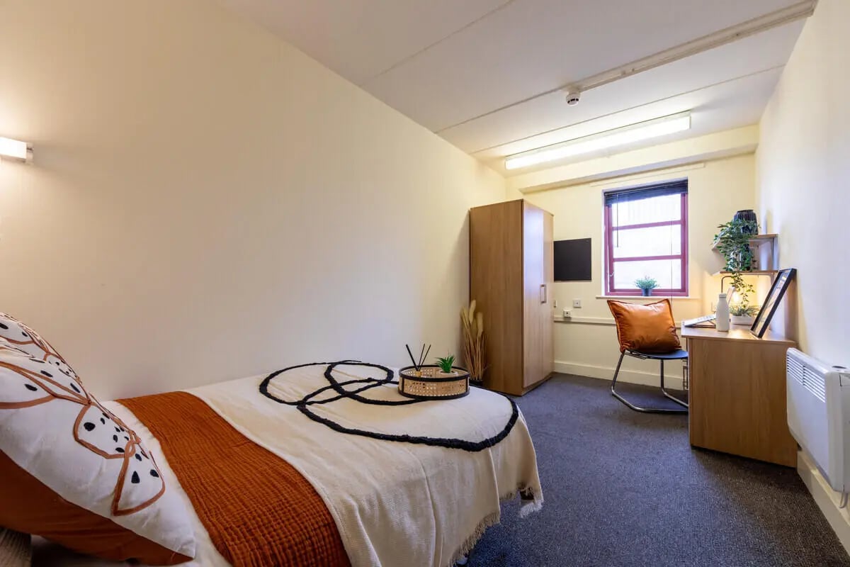Bed wardrobe desk chair window and radiator bedroom at Manchester Student Village in Manchester Student Accommodation