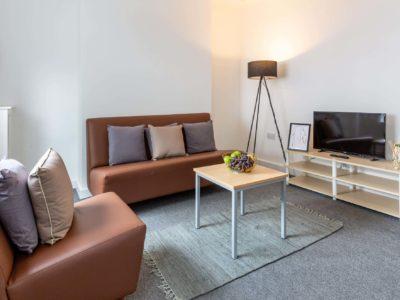 Brown sofa, coffee table, television living room at Harbour Court in Bristol Student Accommodation
