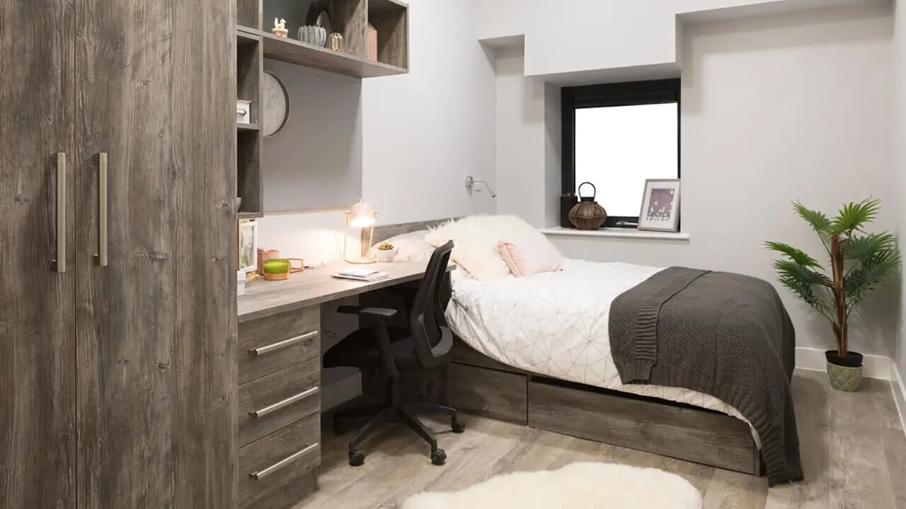 Wardrobe desk bed chair plant bedroom at Collegiate Crown Place Portsmouth in Portsmouth Student Accommodation