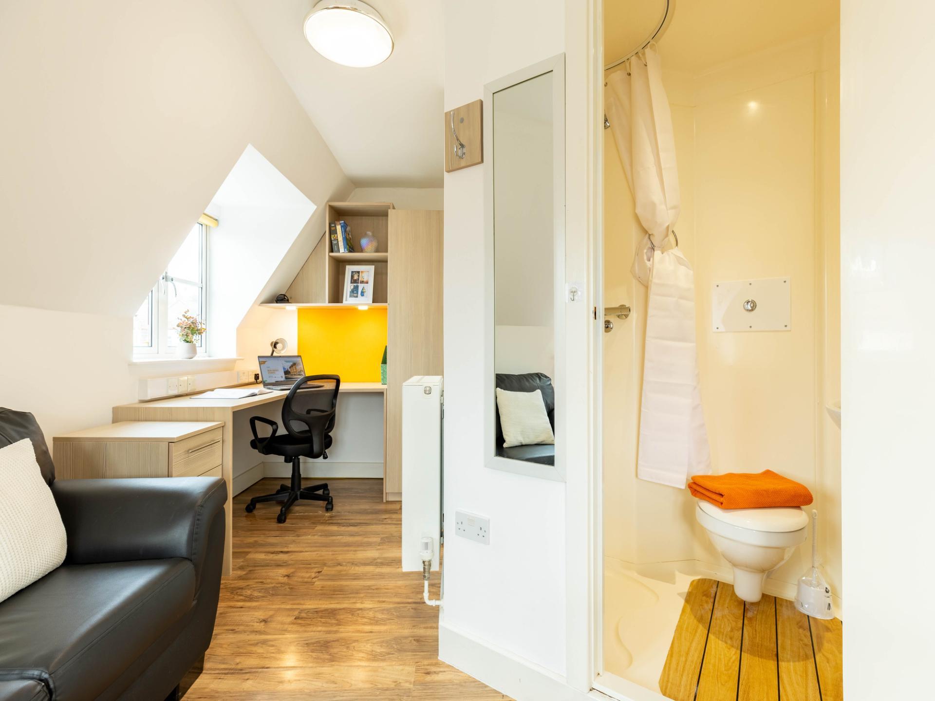 Desk chair sofa and bathroom shower room. at Iron Bridge Studios in Exeter Student Accommodation