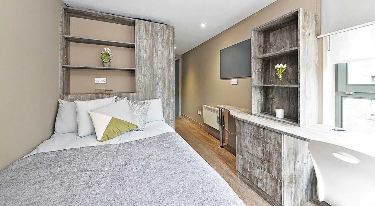 Bed desk shelves and white chair bedroom at Marketgait Apartments in Dundee Student Accommodation