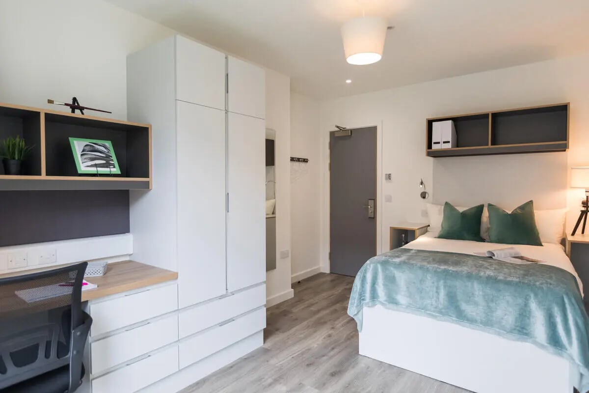 Bed desk wardrobe and shelves bedroom at The Cam Foundry in Cambridge Student Accommodation