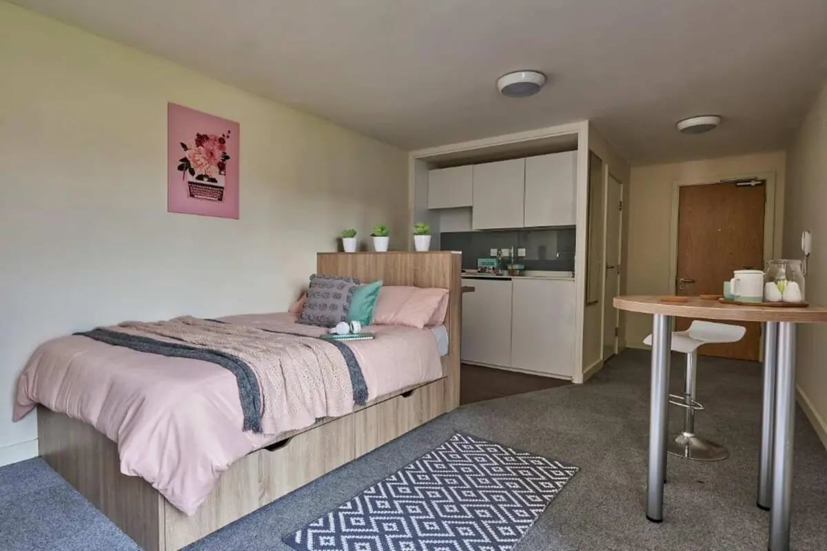 Bed kitchen table with stool interior living room at Selly Oak Court in Birmingham Student Accommodation