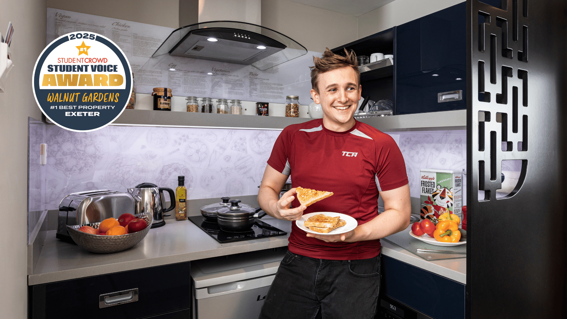Man with toast in modern student accommodation kitchen at Study Inn Walnut Gardens Exeter in Exeter Student Accommodation
