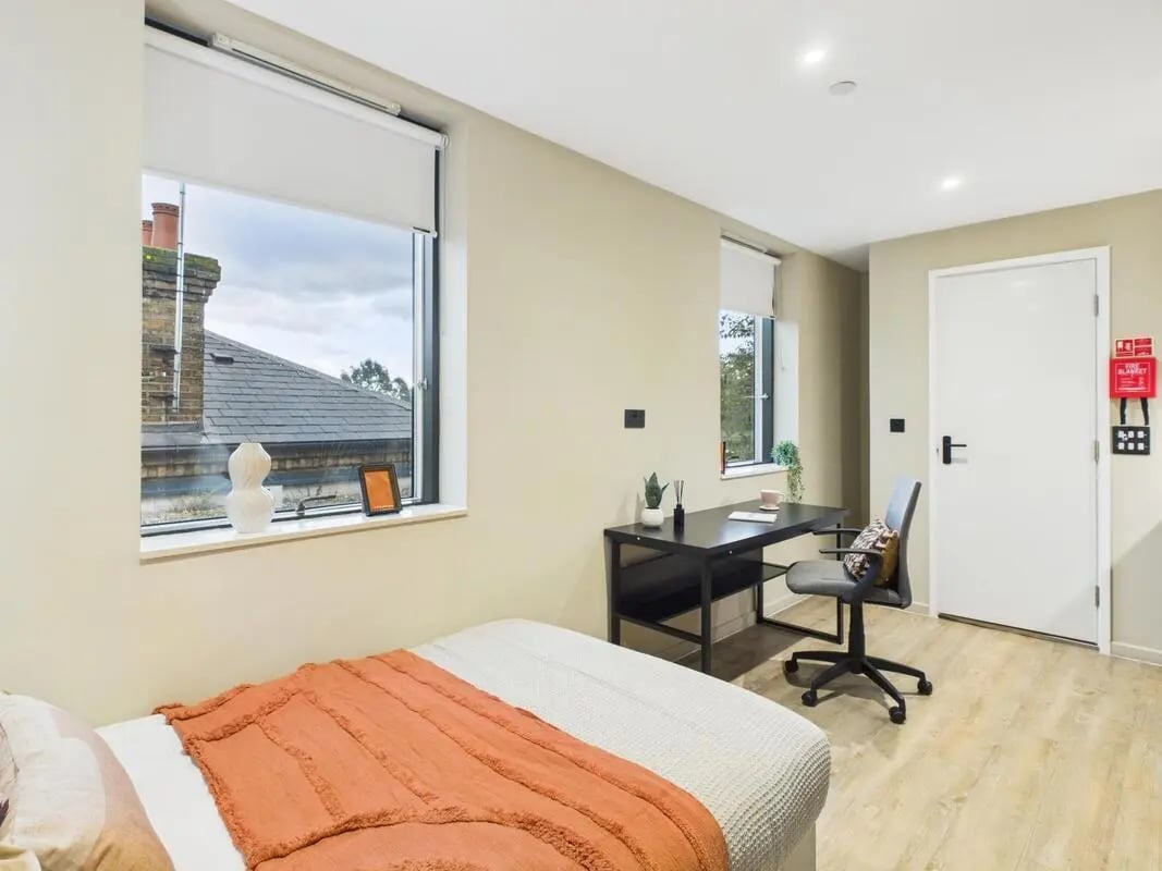 Bed desk chair and fire blanket bedroom at Tribu Kingston in Kingston Upon Thames Student Accommodation
