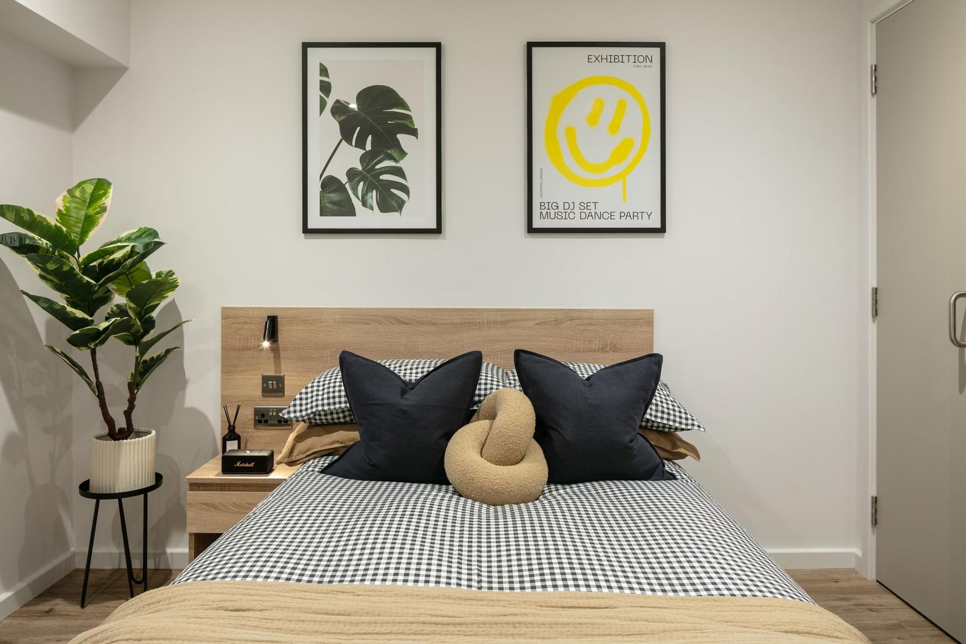 Bed with checkered bedding plant art bedroom at The Fabric Works in Leeds Student Accommodation