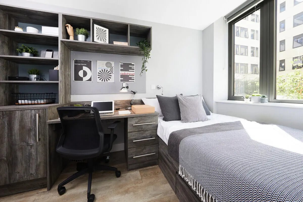 Desk chair shelves bed laptop and window Bedroom at Collegiate Crown Place Cardiff in Cardiff Student Accommodation