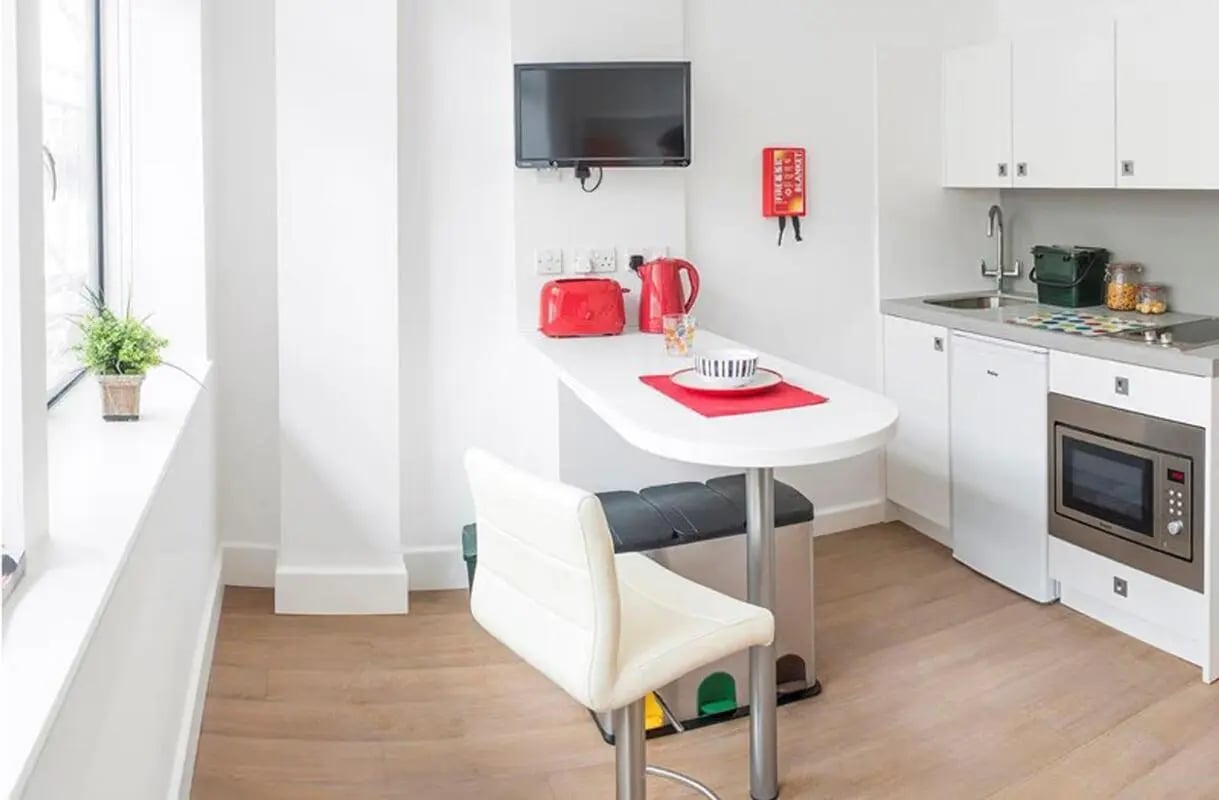 White studio apartment with kitchen and dining area at The Colston in Bristol Student Accommodation