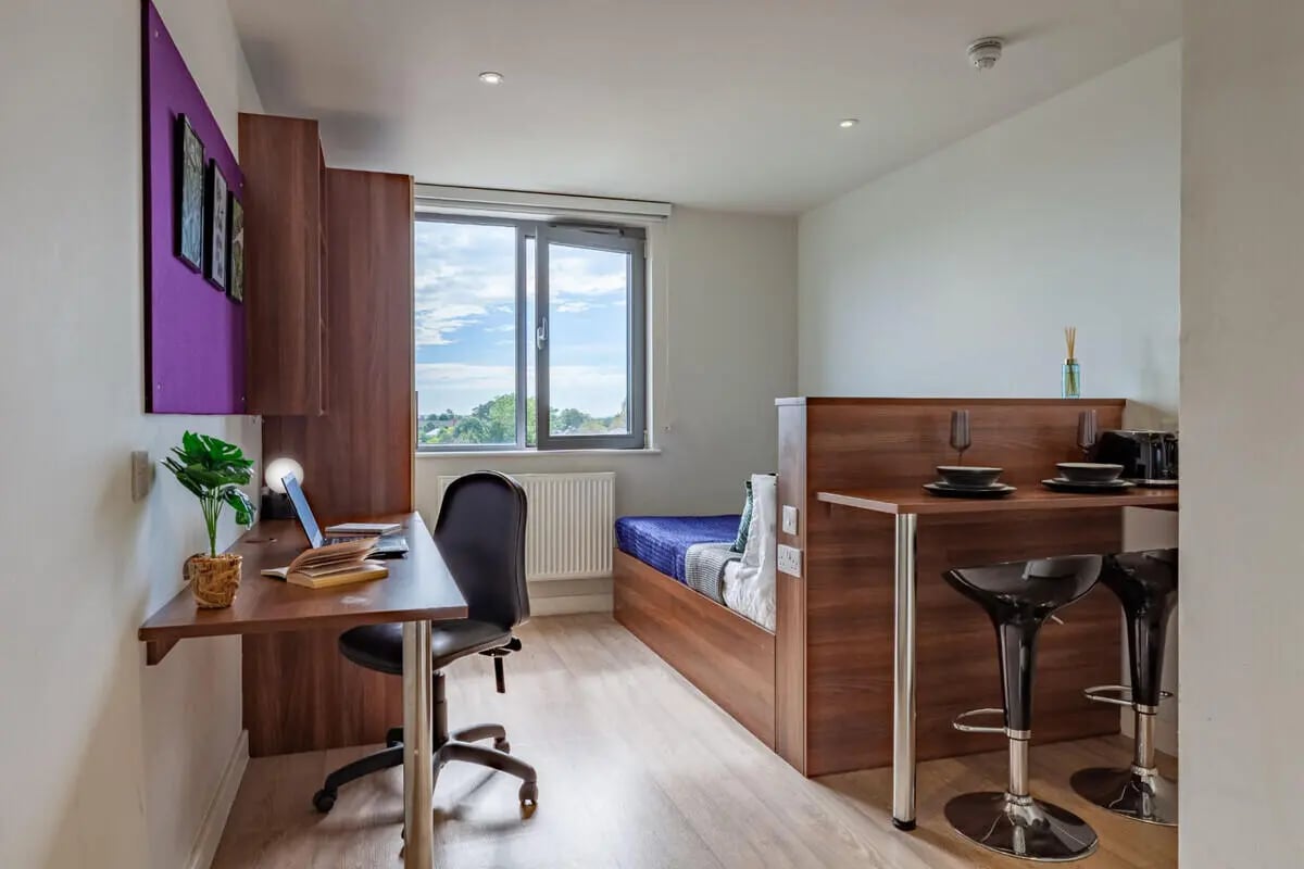 Desk bed bar stools and kitchen counter living room at Central Studios - London in London Student Accommodation