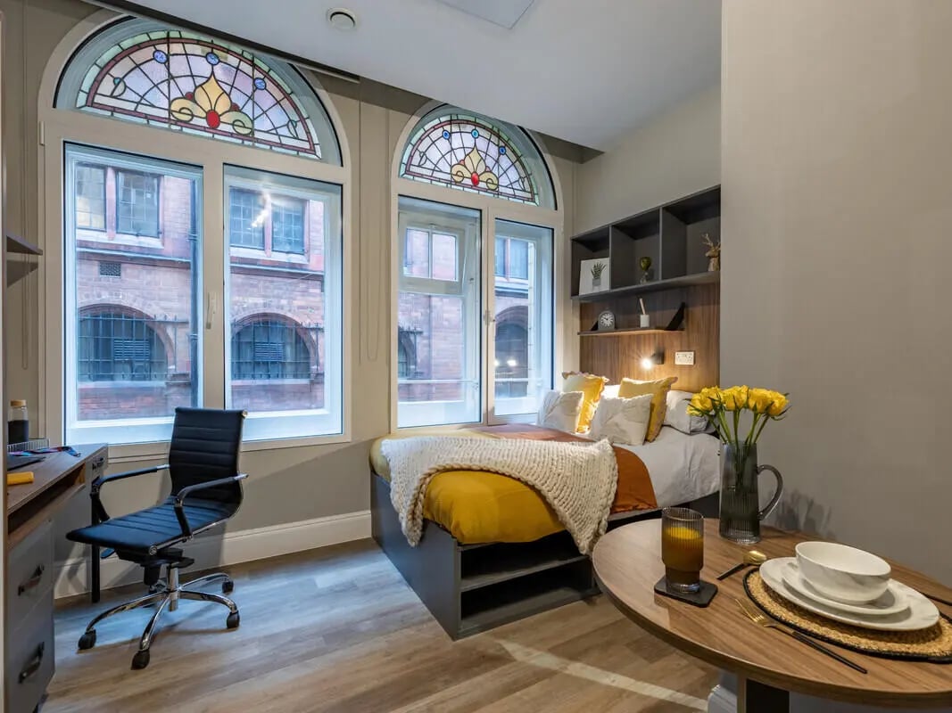Desk chair bed stained glass windows bedroom at Chamberlain Place in Birmingham Student Accommodation