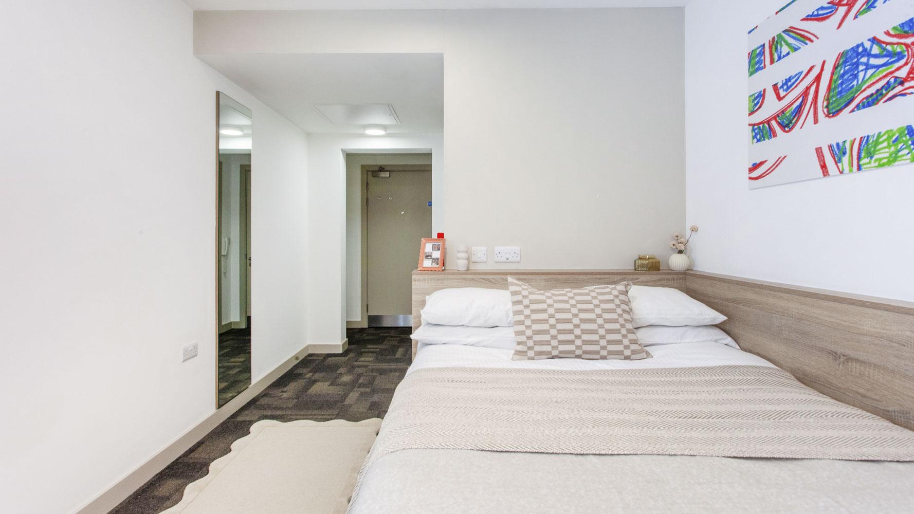 Bed with framed pictures and artwork Bedroom at Berkshire House Reading in Reading Student Accommodation