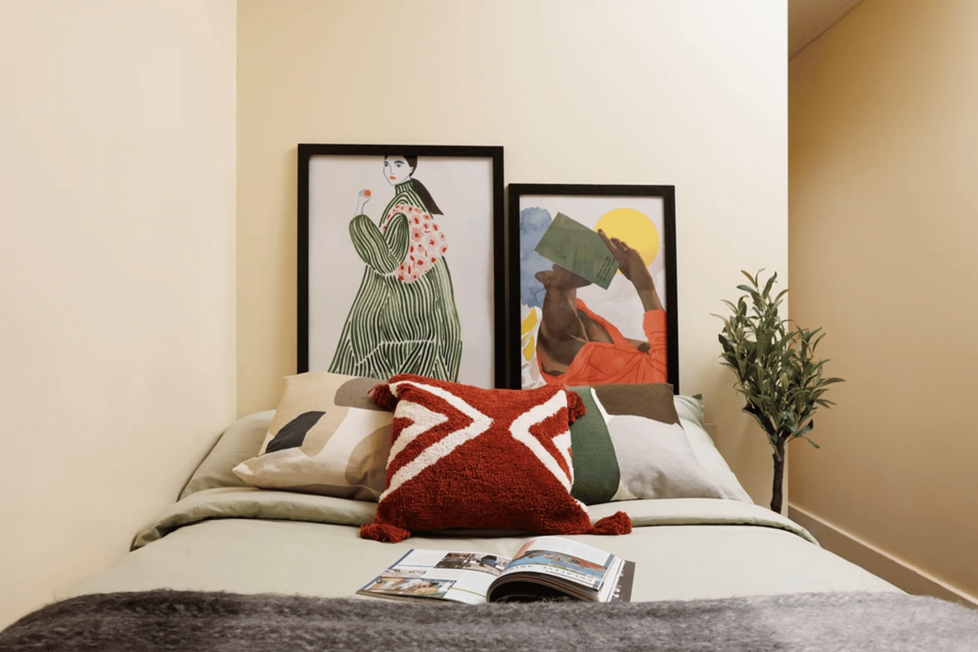 Bed with artwork pillows and plant bedroom at Curzon House in Nottingham Student Accommodation