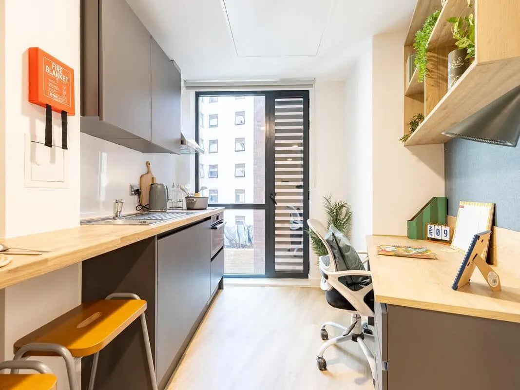 Kitchen with fire blanket and desk study area at Fabric in Nottingham Student Accommodation